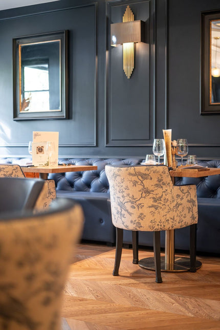 Projet Marianne - salle de restaurant avec banquette bleue, tables en bois et fauteuils à motifs floraux
