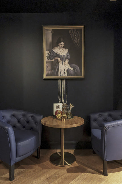 Projet Marianne - coin salon avec fauteuils bleus, table ronde en bois et portrait mural