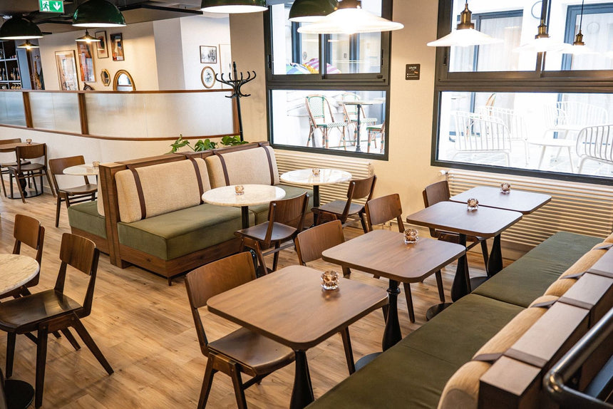 Aménagement de restaurant professionnel avec banquettes vertes, tables en bois et chaises