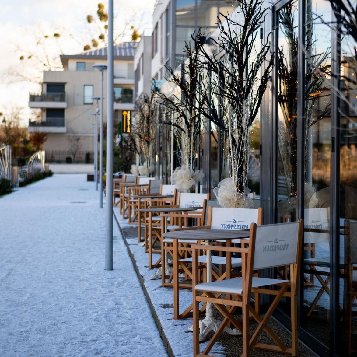 Terrasse du restaurant Le Tropézien à L'Isle-Adam équipée de fauteuils metteur en scène avec logo